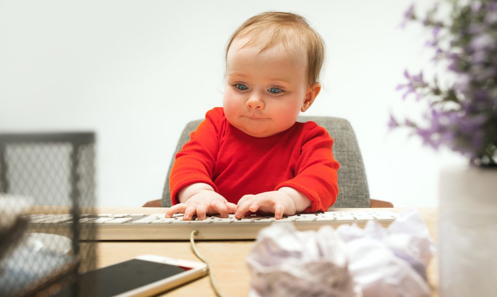 happy child baby girl toddler sitting with keyboard computer isolated white